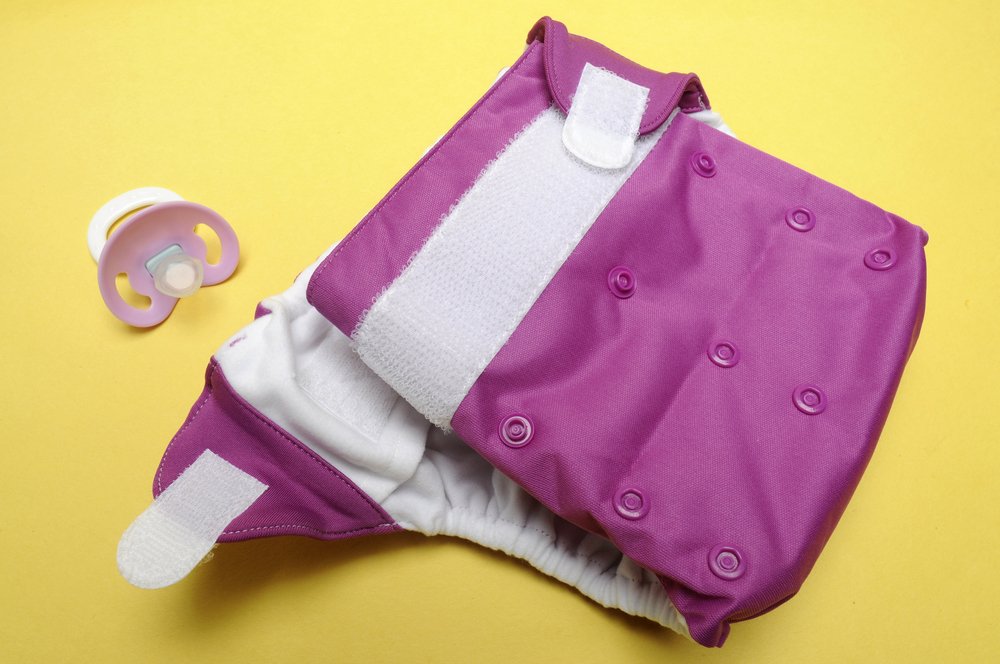 Open Eco Friendly Cloth Diaper with Dummy on Yellow Background